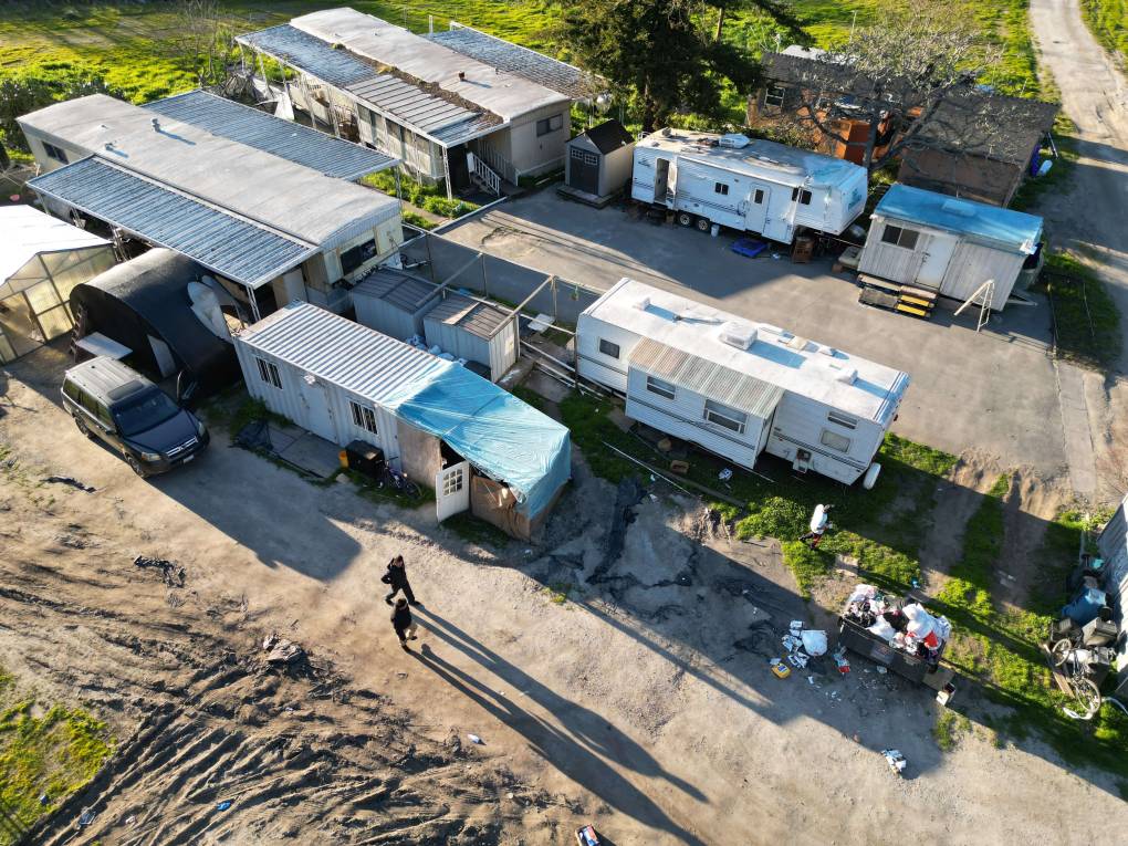 An aerial view of a number of trailers on a farm site.
